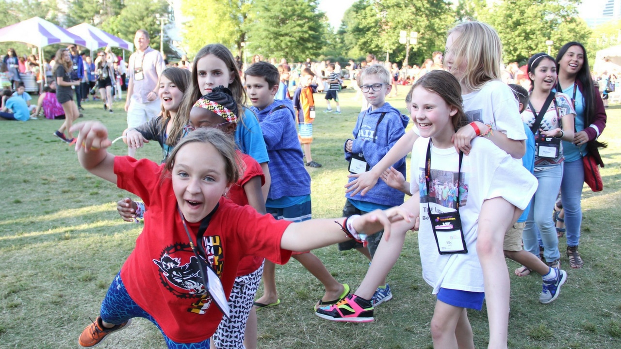 A Destination Imagination team walks together into a Global Finals event in a park.