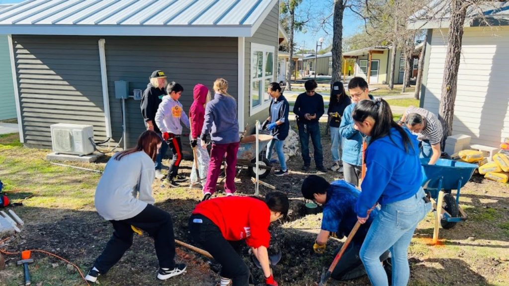 Destination Imagination team, the DI Dynamites, work with residents at Community First! Village in Austin, Texas, to build a water station.