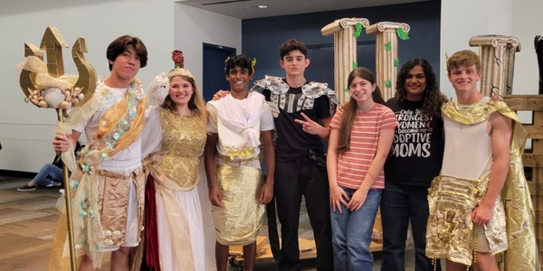 DI team, DIvine, pose for a photo in costume and with props at Global Finals 2025. 