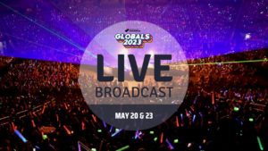 Photo of a large audience inside a stadium for Destination Imagination Global Finals. Text says, "Live Broadcast. May 20 & 23"