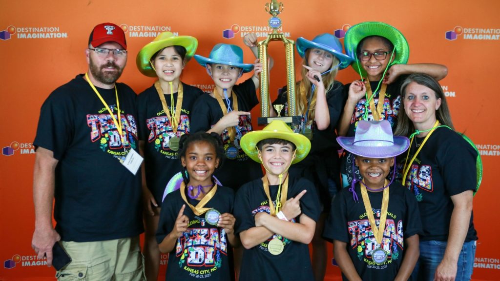 A Global Finals 2023 team, smiling and posing for a photo with their 1st place trophy.