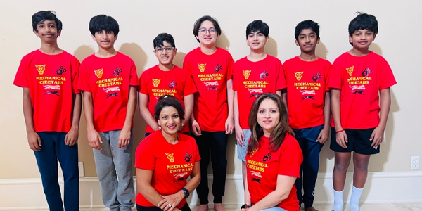 DI team, Mechanical Cheetahs, pose for a photo wearing matching red DI shirts. 