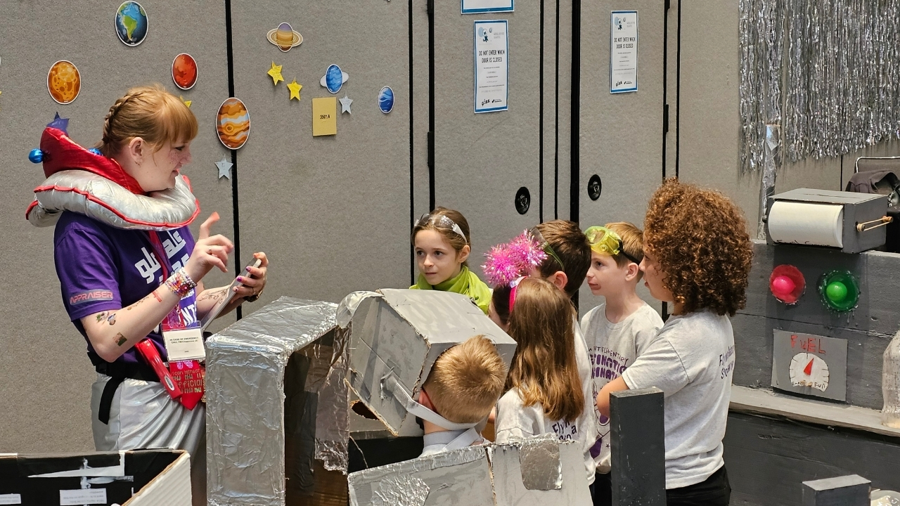 A volunteer Appraiser speaks with a DI team after their performance at Global Finals 2025.