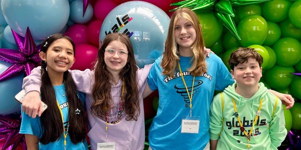 DI team, The Fournadoes, pose for a photo in front of a large, colorful balloon backdrop at Global Finals 2025. 