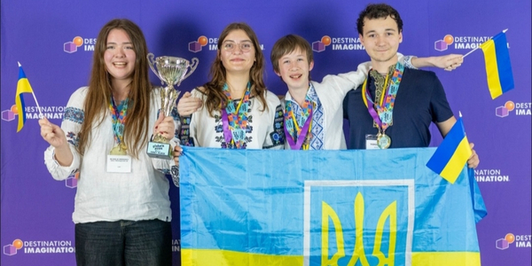 DI team, Vybukh, pose for a photo holding their Global FInals 2025 trophy and the Ukrainian flag. 